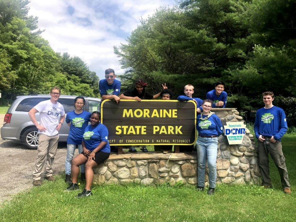 Seven people standing in front of Moraine State Park sign