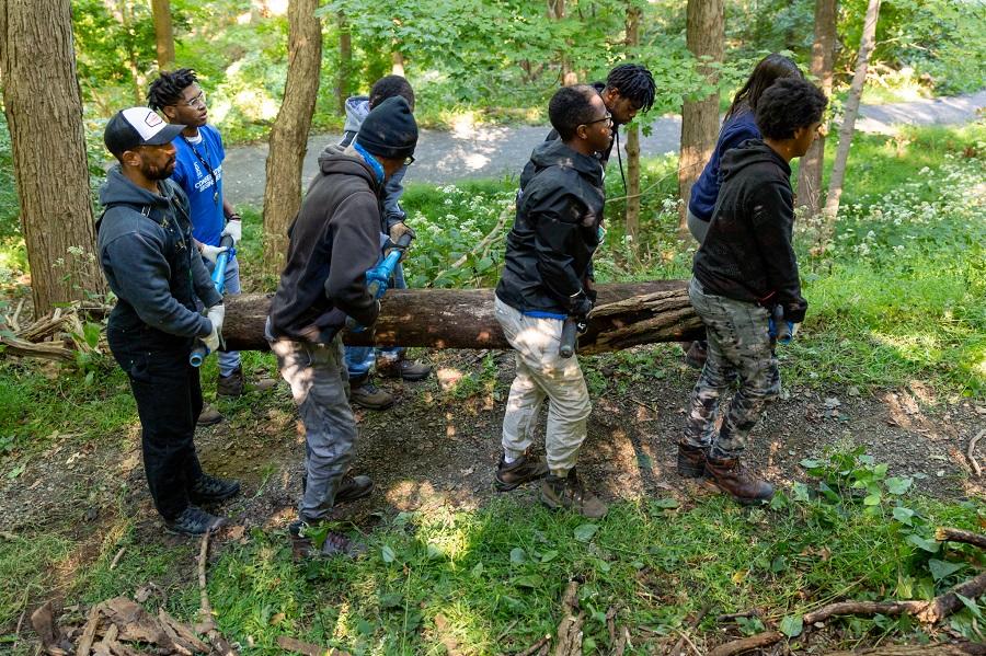 8 people carrying log outside