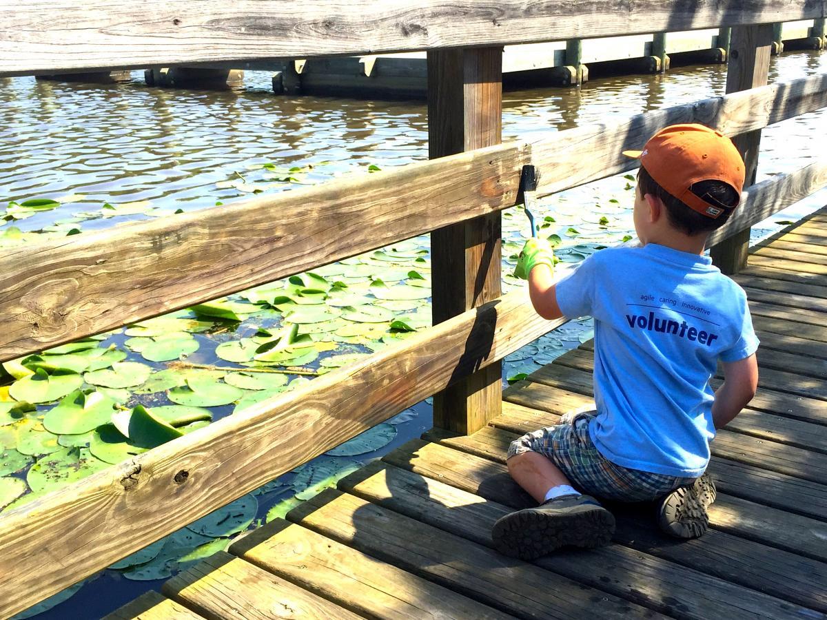 5-year-old volunteer Liam pitches in to help paint the boardwalk