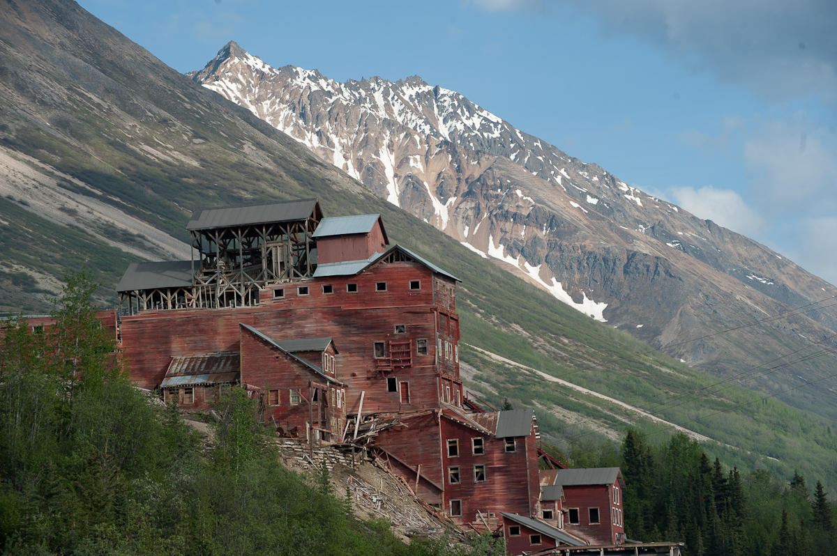Buildings of a town surrounded by partially snowcapped mountains