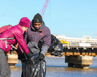 Secretary Jewell and SCA's Roland Richardson work together to clean debris from Washington DC's Anacostia Park